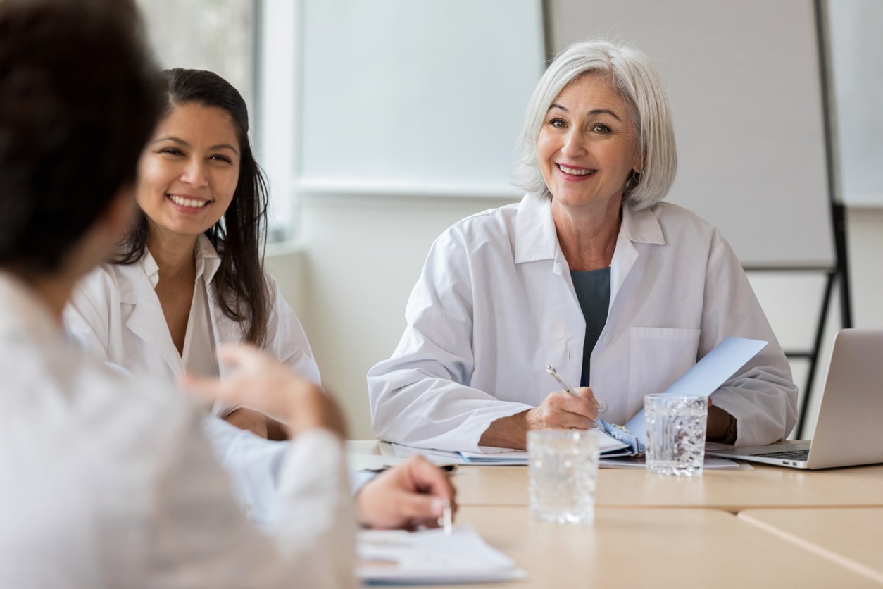 Three medical professionals seated at a table.